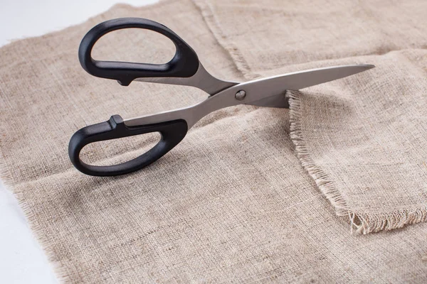 The tailor's scissors cut linen fabric on a white background. — Stock Photo, Image
