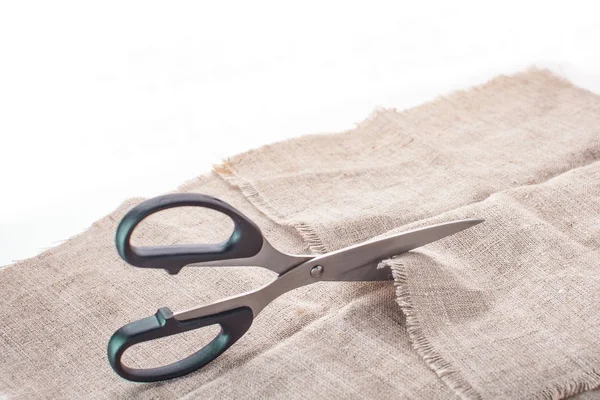 The tailor's scissors cut linen fabric on a white background. — Stock Photo, Image