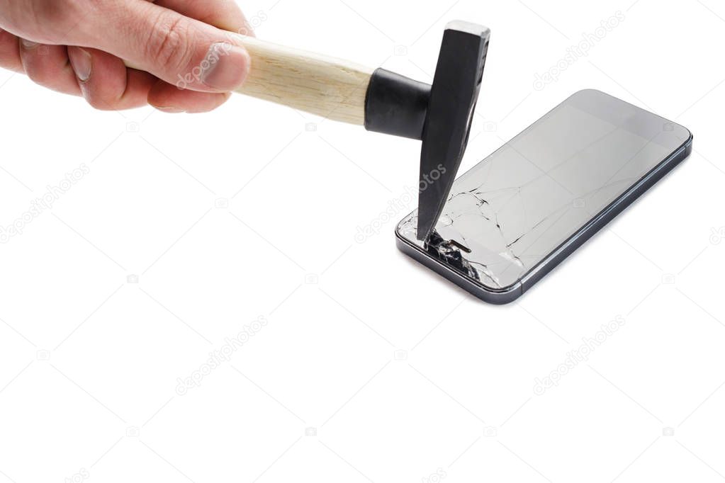 Male hand breaks a smartphone with a hammer against a white back