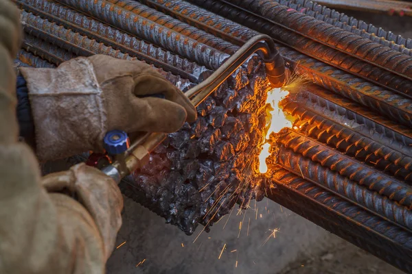 Gas cutting of metal fittings. Working gloves. Sparks.