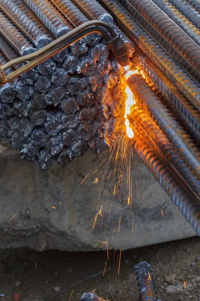 Gas cutting of metal fittings.  Sparks.