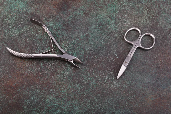 Маникюрные ножницы и ножницы на темном фоне с текстурой — стоковое фото