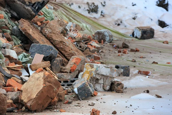A pile of construction debris is broken brick and concrete.