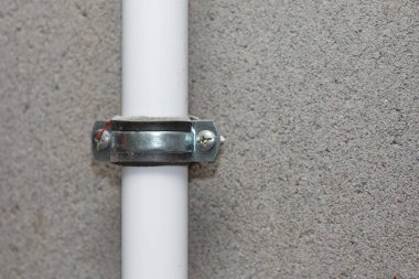 Beyaz boru beton duvara yakın çekim için sıkıştırın.