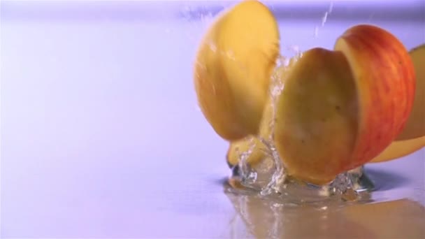 Manzana cayendo En la superficie del agua — Vídeo de stock