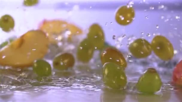 Raisins et pommes tombant dans l'eau — Video