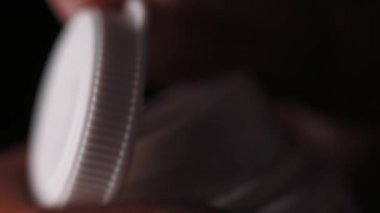 Bir şişe ilaç bir parmak ile açılış.