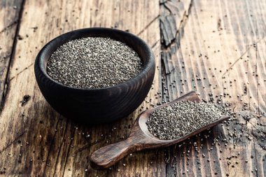 Ahşap rustik arka plan üzerinde ahşap bir kase içinde Chia tohum