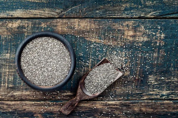 Semi di chia in una ciotola di legno su uno sfondo rustico di legno — Foto Stock