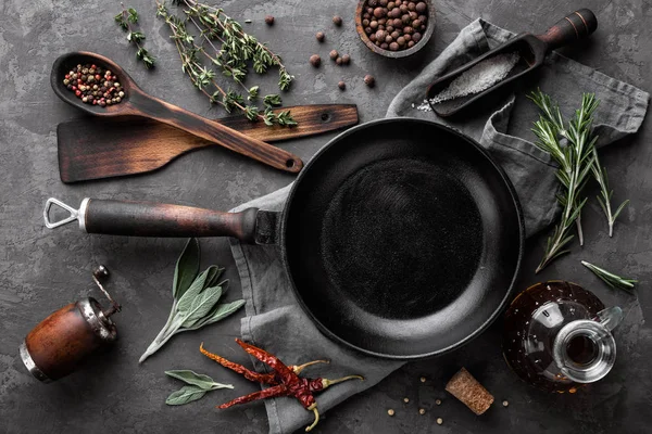 Dunkler kulinarischer Hintergrund mit leerer schwarzer Pfanne und Platz für Textrezept oder Speisekarte — Stockfoto