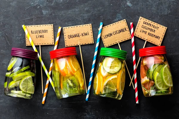 Verscheidenheid van de vruchten geïnfundeerd detox water in potten voor een gezonde voeding eten bovenaanzicht — Stockfoto