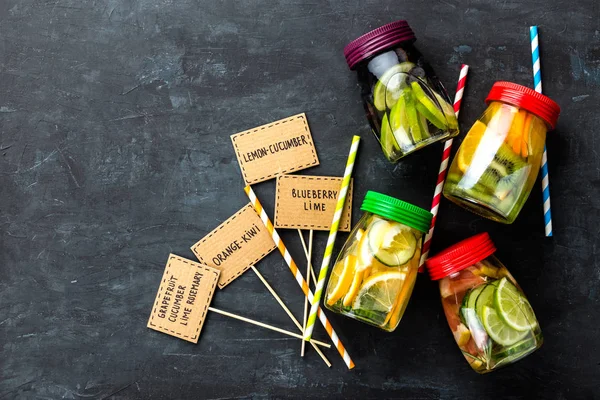 Verscheidenheid van de vruchten geïnfundeerd detox water in potten voor een gezonde voeding eten bovenaanzicht — Stockfoto