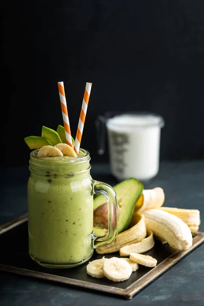 Batido de plátano y aguacate recién mezclado con yogur o leche en tarro de albañil, alimentación saludable —  Fotos de Stock