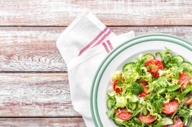 Taze domates, salatalık, ıspanak, frize ve roka plaka üzerinde sağlıklı sebze salatası. vegan yemek. Üstten Görünüm