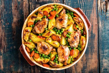 Patates, havuç ve yeşil bezelye ile pişmiş tavuk uyluk
