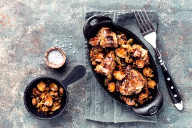 mantar ve soğan dökme demir tabak içinde pişmiş et