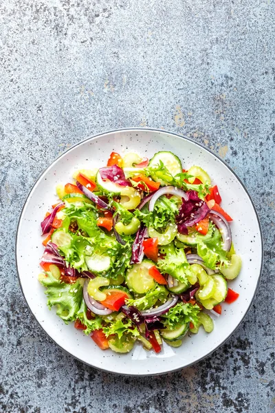 新鲜蔬菜沙拉的黄瓜 雄犬莴苣 红洋葱和芝麻籽橄榄油 健康素食 纯素食食品 — 图库照片