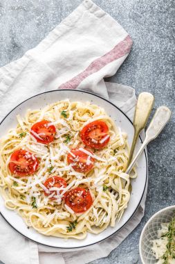 erişte'de bir tabloda bir tabak domates, parmesan peyniri ve baharatlar ile pişmiş
