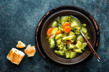 tabak brokoli, patates, yeşil bezelye, soğan ve havuç ile taze sıcak sebze çorbası. sağlıklı vegan diyet gıda, üstten görünüm