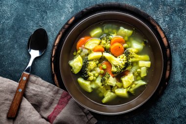 tabak brokoli, patates, yeşil bezelye, soğan ve havuç ile taze sıcak sebze çorbası. sağlıklı vegan diyet gıda, üstten görünüm
