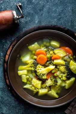tabak brokoli, patates, yeşil bezelye, soğan ve havuç ile taze sıcak sebze çorbası. sağlıklı vegan diyet gıda, üstten görünüm