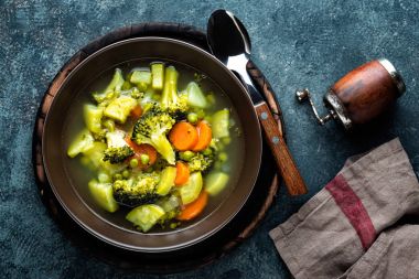 tabak brokoli, patates, yeşil bezelye, soğan ve havuç ile taze sıcak sebze çorbası. sağlıklı vegan diyet gıda, üstten görünüm