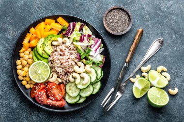 Vejetaryen salata Buda kase tabak kahverengi pirinç, avakado, biber, domates, salatalık, nohut, chia tohum, taze marul salatası ve kaju fıstığı ile. Sağlıklı yeme eğilimi, superfood. Üstten Görünüm