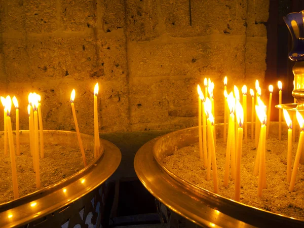 Горящие свечи внутри каменной часовни — стоковое фото