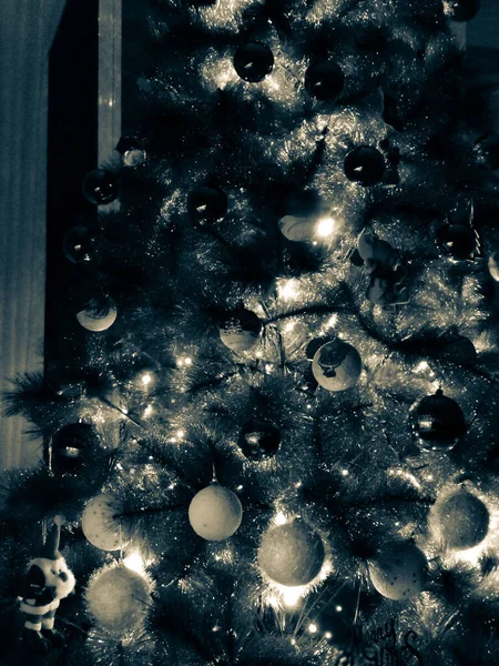 Monochromatyczne zdjęcie choinki z białymi i czarnymi prezentami w nocy — Zdjęcie stockowe