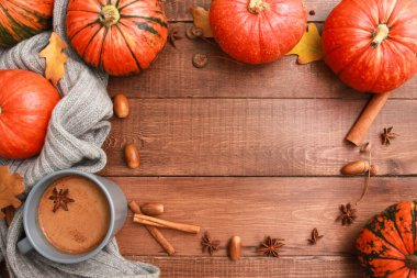 Süt ve baharatlı gri kahve kupası, ekose, sarı meşe yaprağı, koyu ahşap masada turuncu balkabağı. Sonbahar içkisi konsepti. Sonbahar, balkabağı baharatlı latte, şükran günü, üst, kopyalama alanı, çerçeve, kenar