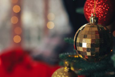 Noel ağacında asılı altın pırıltısı. Arka plan bulanık. Balo, yeni yıl, kutlama, tatil, iç mekan, hafif bokeh, kopyalama alanı