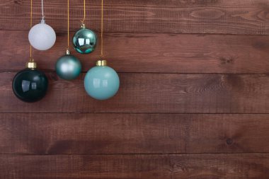 Ahşap, kahverengi duvarda asılı Noel mücevherleri. Yeni yıl ve Noel geçmişi kavramı. Boşluğu, topu, kar tanesini kopyala