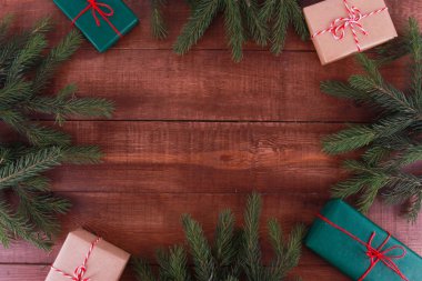 Firavun ağacı dalları, kahverengi tahta masadaki hediye kutuları. Noel konsepti. Yeni yıl, kış tatili, fotokopi alanı, üst manzara, sınır