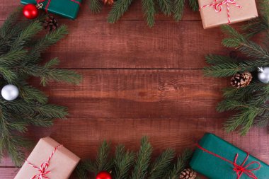 Firavun ağacı dalları, hediyeler, incik boncuklar, kahverengi ahşap masadaki koniler. Noel konsepti. Yeni yıl, kış tatili, fotokopi alanı, üst manzara, sınır