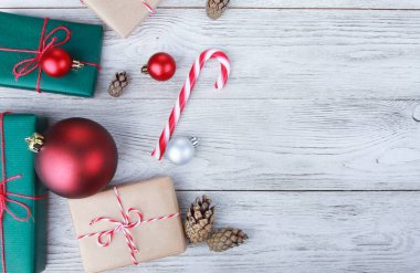 Noel mücevherleri, hediyeler, baston şekerler, beyaz ahşap masadaki köknar kozalakları. Noel konsepti. Yeni yıl, kış tatili, fotokopi alanı, üst manzara