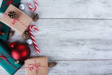 Noel mücevherleri, hediyeler, baston şekerler, beyaz ahşap masadaki köknar kozalakları. Noel konsepti. Yeni yıl, kış tatili, fotokopi alanı, üst manzara
