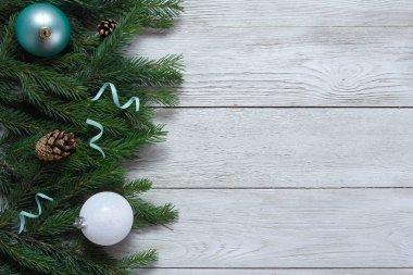 Nane ve beyaz Noel süslemeleri, süslemeler, beyaz ahşap masada köknar dalları. Noel arkaplanı. Yeni yıl, kış tatili, fotokopi alanı, üst manzara