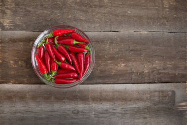 Ahşap bir masada kasede kırmızı biber.