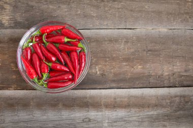 Ahşap bir masada kasede kırmızı biber.