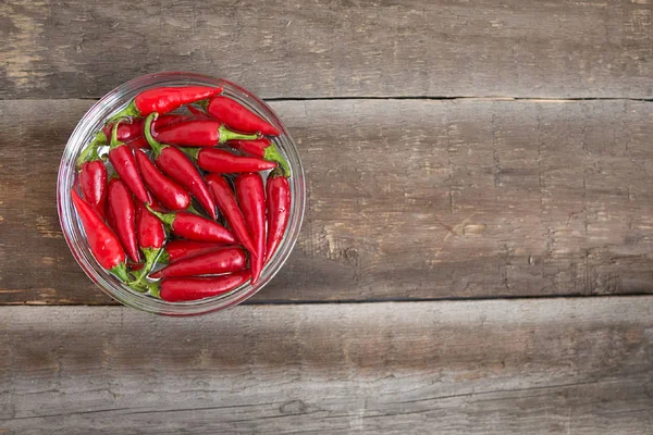 Ahşap bir masada kasede kırmızı biber.