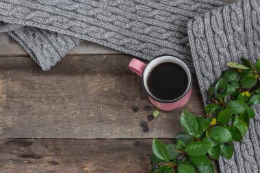 ahşap bir masa üzerinde gri bir Fularlı pembe kupa