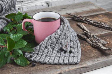 ahşap bir masa üzerinde gri bir Fularlı pembe kupa