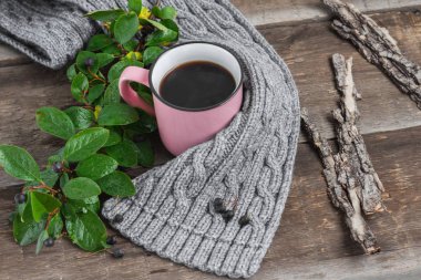 ahşap bir masa üzerinde gri bir Fularlı pembe kupa