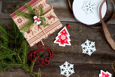 Hediye kutusu ve ahşap arka planda süslemeleri olan Noel ağacı