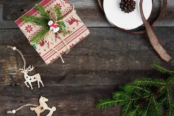 Hediye kutusu ve ahşap arka planda süslemeleri olan Noel ağacı