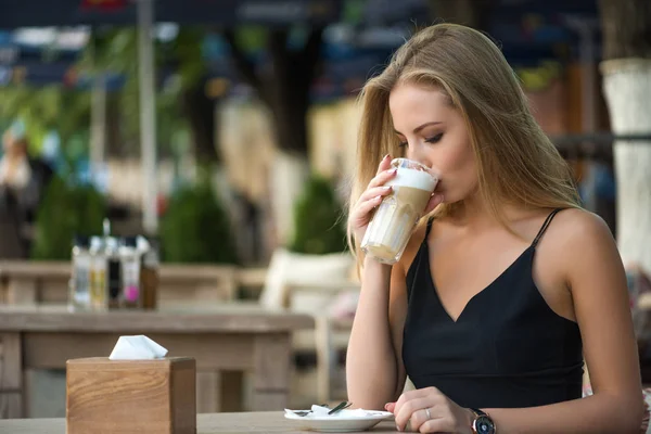 Kafede kahve içen bir kız.