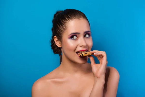 Kız bir çerez üzerinde mavi artalanları ısırma