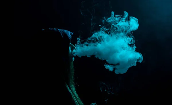 Девушка в капюшоне курит — стоковое фото