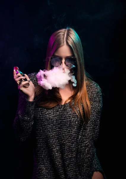 Kız vaping siyah artalanları üzerinde