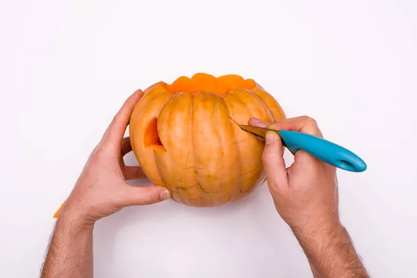 adam Cadılar Bayramı için bir festival balkabağı fener yapar.